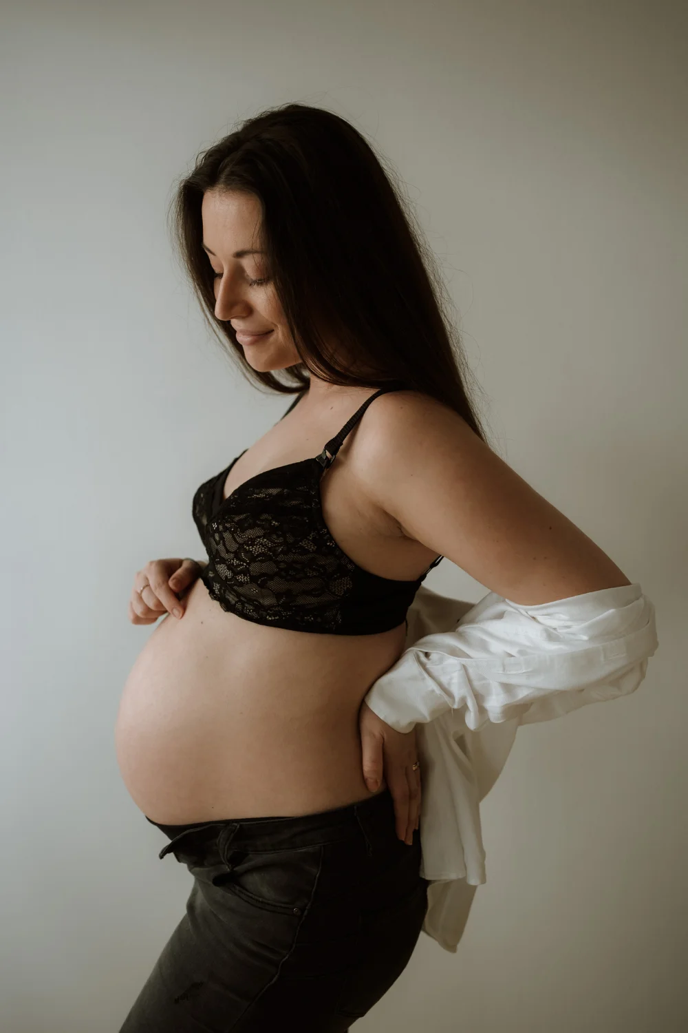 těhotná žena ve spodním prádle hladí své bříško