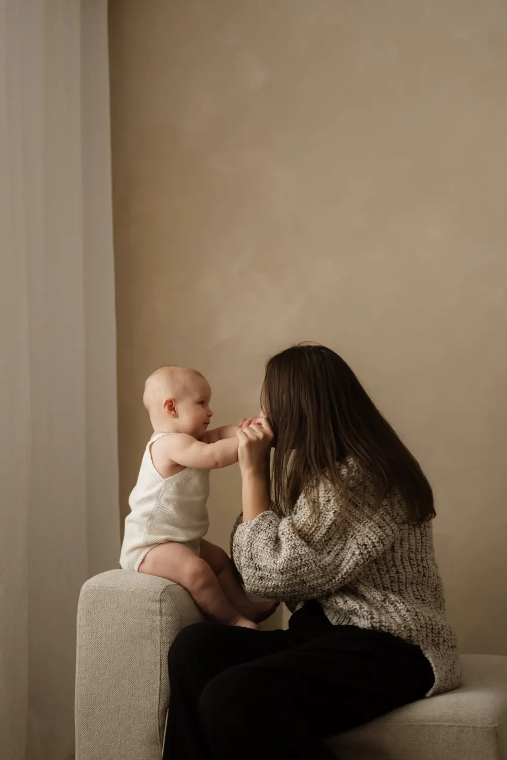 maminka s batoletem sedí na křesle při focení v ateliéru